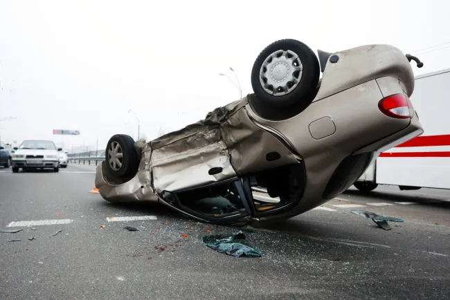 Car flipped upside down on the road