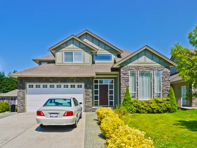 Car parked in the driveway of a suburban house